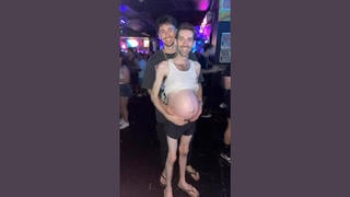 Fact Check: Multiple Glitches Reveal Two Different FAKE AI-Generated Scenes Of A Pregnant Man With His Partner At A Nightclub